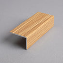 Oak effect aluminium stair nosing 25mm x 10mm shown alone on a plain studio background, L-angle and grooved top face visible