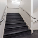 Black anodised aluminium stair nosing fitted across the full width of dark LVT stair treads