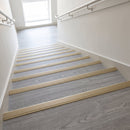 Champagne anodised aluminium stair nosing fitted across the full width of grey LVT stair treads