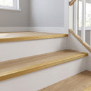 Gold anodised aluminium stair nosing fitted across the full width of oak LVT stair treads