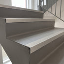 Inox anodised aluminium 35x35mm ribbed stair nosing fitted to grey commercial vinyl steps in a public stairwell