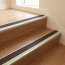 Brown insert aluminium stair nosing fitted to oak effect laminate treads on a hotel staircase