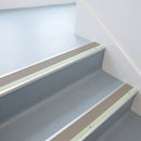 Dolphin grey insert aluminium stair nosing fitted to pale blue grey safety vinyl treads in a clinic staircase