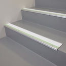 White insert aluminium stair nosing fitted along the edge of grey resin office stairwell steps