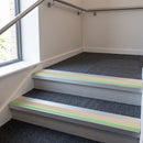 57x55mm rake back aluminium stair nosing with canvas PVC insert and green photoluminescent nose strip fitted in a stairwell