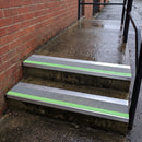 57x55mm external rake back stair nosing with dolphin grey Tredsafe coarse grit insert and green photoluminescent strip fitted to wet outdoor concrete steps