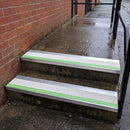 57x55mm external rake back stair nosing with white Tredsafe coarse grit insert and green photoluminescent strip fitted to wet outdoor concrete steps