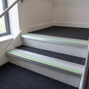 57x55mm rake back aluminium stair nosing with ice grey PVC insert and green photoluminescent nose strip fitted on office stairs