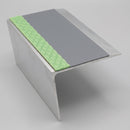 57x55mm rake back aluminium stair nosing profile showing the deep raked riser leg, green photoluminescent strip and grey PVC insert