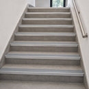Aluminium rakeback stair nosings with dolphin grey anti-slip inserts fitted to every step of a grey tiled internal staircase