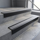 Black Anodised square edge aluminium stair nosing with Flint Castellated infill, fitted to a concrete step