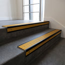 Black Anodised square edge aluminium stair nosing with Gold Castellated infill, fitted to a concrete step