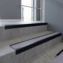 Black Anodised square edge aluminium stair nosing with Nimbus Castellated infill, fitted to a concrete step