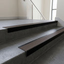 Black Anodised square edge aluminium stair nosing with Peat Castellated infill, fitted to a concrete step
