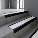 Black Anodised square edge aluminium stair nosing with White Castellated infill, fitted to a concrete step
