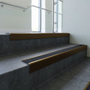 Bronze square edge aluminium stair nosing with Black Olympic Grip infill, fitted to a concrete step