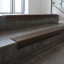 Bronze square edge aluminium stair nosing with Peat Castellated infill, fitted to a concrete step