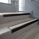 Bronze square edge aluminium stair nosing with Polar Grey Castellated infill, fitted to a concrete step