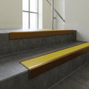 Bronze square edge aluminium stair nosing with Yellow Castellated infill, fitted to a concrete step