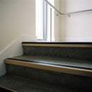 Light Bronze square edge aluminium stair nosing with Black Smooth Textured infill, fitted to a concrete step