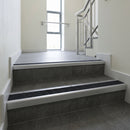 Mill Aluminium square edge aluminium stair nosing with Black Olympic Grip infill, fitted to a concrete step