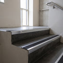 Polished Aluminium square edge aluminium stair nosing with Black Castellated infill, fitted to a concrete step