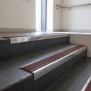 Polished Aluminium square edge aluminium stair nosing with Claret Castellated infill, fitted to a concrete step