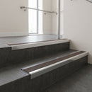 Polished Aluminium square edge aluminium stair nosing with Peat Castellated infill, fitted to a concrete step