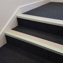 Beige insert 63mm x 32mm aluminium stair nosing with photoluminescent front strip fitted to carpeted office steps