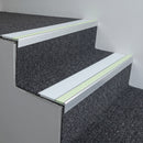 Ice Grey insert 63mm x 32mm aluminium stair nosing with photoluminescent front strip fitted to carpeted office steps
