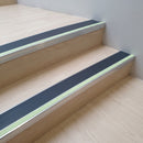 Midnight Grey insert 63mm x 32mm aluminium stair nosing with photoluminescent front strip fitted to pale timber steps