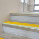 Aluminium stair nosings with a yellow anti-slip insert and photoluminescent front strip fitted to concrete steps in an office stairwell