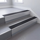Black Castellated insert in a 66x55mm square front aluminium stair nosing with 13mm Light Grey riser highlight, fitted to interior steps