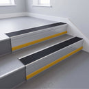 Black Castellated insert in a 66x55mm square front aluminium stair nosing with 13mm Yellow riser highlight, fitted to interior steps