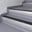 Black Olympic Grip insert in a 66x55mm square front aluminium stair nosing with 13mm Polar Grey riser highlight, fitted to interior steps