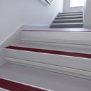 Claret Castellated insert in a 66x55mm square front aluminium stair nosing with 13mm Polar Grey riser highlight, fitted to interior steps