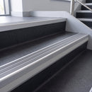 Flint Castellated insert in a cut to size 66x55mm aluminium stair nosing with 13mm Polar Grey riser highlight, fitted to interior steps