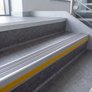 Flint Castellated insert in a 66x55mm square front aluminium stair nosing with 13mm Yellow riser highlight, fitted to interior steps