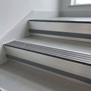 Granite Castellated insert in a 66x55mm square front aluminium stair nosing with 13mm Light Grey riser highlight, fitted to interior steps