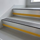 Granite Castellated insert in a 66x55mm square front aluminium stair nosing with 13mm Yellow riser highlight, fitted to interior steps