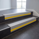 Light Grey Castellated insert in a 66x55mm square front aluminium stair nosing with 13mm Yellow riser highlight, fitted to interior steps