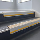 Porth Stone Castellated insert in a 66x55mm square front aluminium stair nosing with 13mm Yellow riser highlight, fitted to interior steps