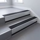 Black Castellated insert in a cut to size 66x55mm aluminium stair nosing with 13mm black riser highlight, fitted to interior steps