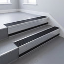 Black Castellated insert in a 66x55mm square front aluminium stair nosing with 13mm black riser highlight, fitted to interior steps
