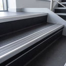 Flint Castellated insert in a 66x55mm square front aluminium stair nosing with 13mm black riser highlight, fitted to interior steps