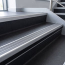 Flint Castellated insert in a cut to size 66x55mm aluminium stair nosing with 13mm black riser highlight, fitted to interior steps