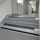 Nimbus Castellated insert in a 66x55mm square front aluminium stair nosing with 13mm black riser highlight, fitted to interior steps