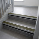 Olive Castellated insert in a 66x55mm square front aluminium stair nosing with 13mm black riser highlight, fitted to interior steps