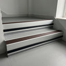 Peat Castellated insert in a 66x55mm square front aluminium stair nosing with 13mm black riser highlight, fitted to interior steps