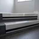 Polished Aluminium insert in a 66x55mm square front aluminium stair nosing with 13mm black riser highlight, fitted to interior steps